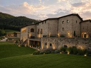 a large stone building with lights on the lawn at Hotel Finca Llongarriu - Only Adults in Vall de Bianya