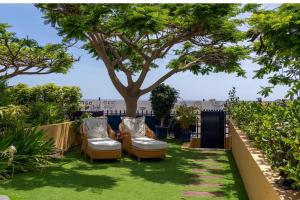 a yard with two chairs and a tree at Meloneras in Meloneras