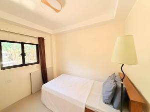 a bedroom with a bed with a lamp and a window at Medecielo Villa in San Fernando