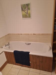 a bath tub in a bathroom with a picture on the wall at Glen Lyon in Inverurie +5 photos