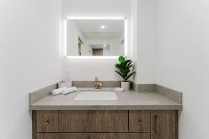 a bathroom with a sink and a mirror at Villa Verde - Boca Pool & Beach Walk in Boca Raton