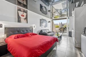 a bedroom with a red bed and a chair at Studio Naturiste Design in Cap d'Agde