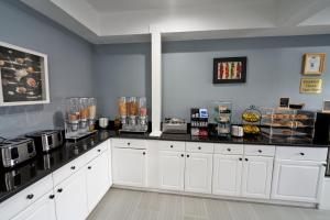 a kitchen with white cabinets and a counter top at Admiralty Inn & Suites - a Red Collection Hotel in Falmouth +40 photos