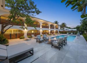 a hotel patio with tables and chairs and a pool at Villa Verde - Boca Pool & Beach Walk in Boca Raton +38 photos