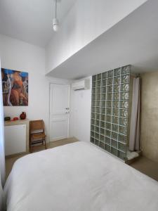 a bedroom with a white bed and a green tile wall at Sublime chambre à endoume proche mer in Marseille