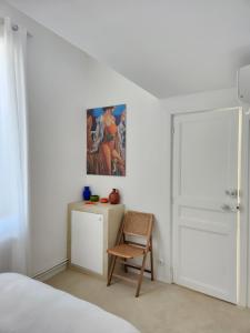 a bedroom with a chair and a painting on the wall at Sublime chambre à endoume proche mer in Marseille +9 photos
