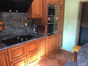 a kitchen with wooden cabinets and a stove top oven at Sunny seaside place in Jūrmala