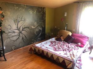 a bedroom with a bed with a flower pattern on the wall at Sunny seaside place in Jūrmala