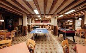 a restaurant with two ping pong tables in a room at Hotel Ludwigshof & Luvina in Trodena