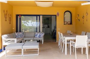 a living room with a couch and a table and chairs at Meloneras in Meloneras