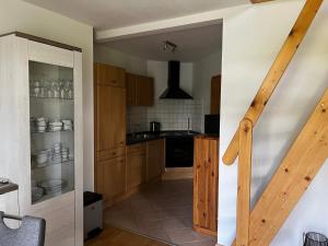 a small kitchen with wooden cabinets and a staircase at Landhaus Baumhöfer in Apen