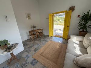 a living room with a couch and a yellow door at Casita Malacitano, Caminito del Rey in Valle de Abdalagís
