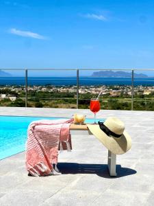 a hat sitting on a bench next to a pool at Villa Demirà - Boutique Rooms & Panoramic Pool in Marsala +101 photos
