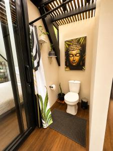 a bathroom with a toilet and a statue of a head at Private Luxury A-Frame with Jacuzzi & Mountain View in San Francisco
