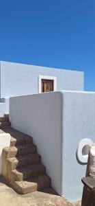 a set of stairs next to a wall with a door at Casa del Limone in Filicudi +20 photos