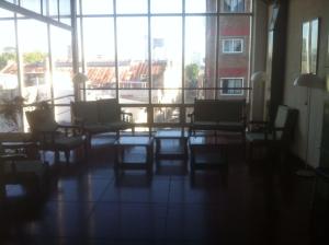 Habitación con sillas, mesa y ventanas grandes. en Hotel Aoma Buenos Aires en Buenos Aires
