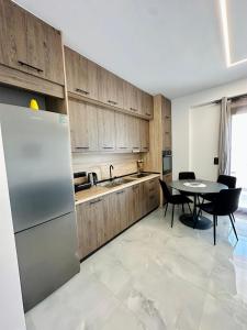 a kitchen with a stainless steel refrigerator and a table at Fanari Meltemi Apartment in Fanari