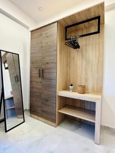 a dressing room with wooden doors and a mirror at Fanari Meltemi Apartment in Fanari +20 photos