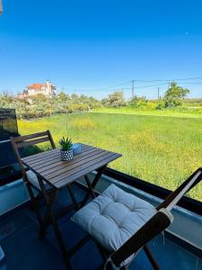 a table and chairs on a balcony with a view of a field at Fanari Meltemi Apartment in Fanari
