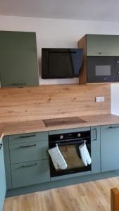 a kitchen with a stove and a wooden counter top at Charming apartment overlooking the valley in Briançon