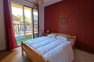 a bedroom with a bed and a large window at Charming apartment overlooking the valley in Briançon