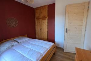 a bedroom with a large bed and a wooden door at Charming apartment overlooking the valley in Briançon