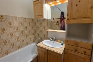 a bathroom with a sink and a bath tub at Charming apartment overlooking the valley in Briançon +5 photos