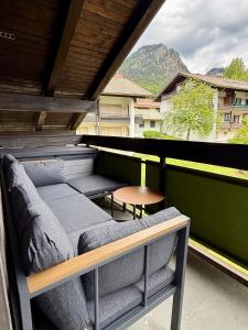 a balcony with couches and a table and a view at Bergheimat Stüble Allgäu in Bad Hindelang