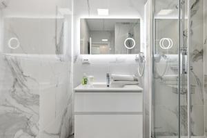 a white bathroom with a sink and a shower at Studio Naturiste Design in Cap d'Agde +138 photos