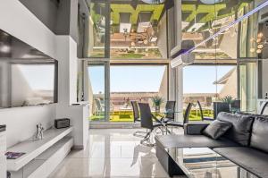 a living room with a couch and some windows at Studio Naturiste Design in Cap d'Agde