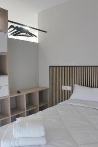 a bedroom with a white bed with a wooden headboard at Apartamentos Dulce Estrela in Tui