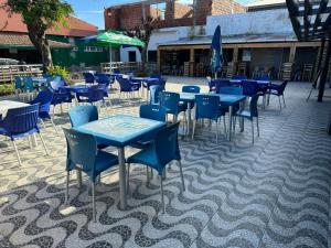 a group of blue tables and chairs on a patio at Hotel Monte Verde in Beira