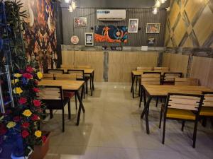 a dining room with wooden tables and chairs at Blueberry Premium Hotel in Greater Noida
