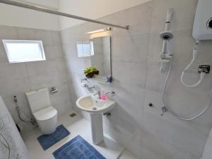 a bathroom with a shower and a toilet and a sink at Keshiya Holiday Home in Nuwara Eliya