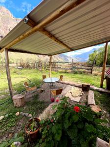 a patio with a table and chairs under a tent at Awki Wasi - Sacred Valley in Lamay