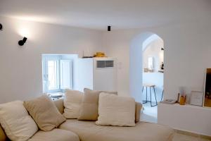 a white living room with a couch with pillows at Casa Amore in Ermoupoli