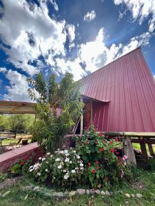 a red barn with flowers in front of it at Awki Wasi - Sacred Valley in Lamay
