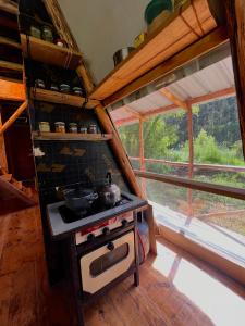 a kitchen with a stove in a room with a window at Awki Wasi - Sacred Valley in Lamay