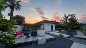 a backyard with chairs and a house with a sunset at Villa Leonessa in Tremestieri Etneo