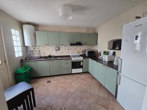 a kitchen with green cabinets and a white refrigerator at Finca Don Celestino in La Banda