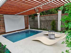 a swimming pool with two chairs and a projection screen at Harmony Hideaway 2 in Gabala