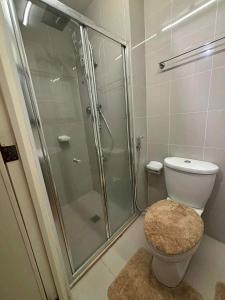 a bathroom with a glass shower and a toilet at JJ Staycation Tower 2 in Manila +14 photos