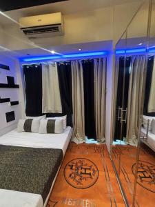 a room with a bed with blue lights in it at JJ Staycation Tower 2 in Manila