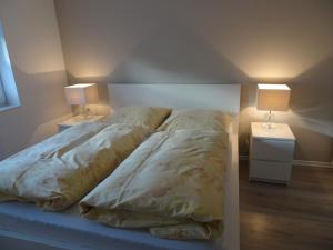 戴德斯海姆的住宿－Apartment am Weinberg，一张位于房间的床,桌子上放着两盏灯