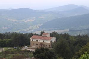 a building on a hill with mountains in the background at Albergue Niu d'Estels in Albiol