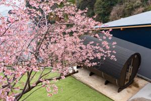 a tree with pink flowers on it next to a building at 河津Blue Ocean in Kawazu