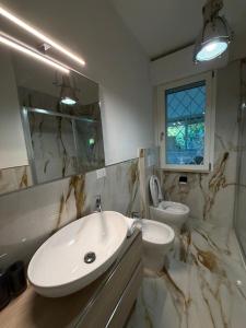 a white bathroom with a sink and a toilet at Effealatapartments - L'Oasi del Forte in Forte dei Marmi +54 photos