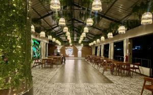 a dining room with tables and chairs and chandeliers at Mercedes Lodge in San Ramón