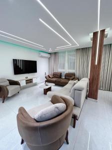 a living room with couches and a flat screen tv at Comfy 3 Bedrooms Apartment in Cairo Sheraton Airport in Cairo