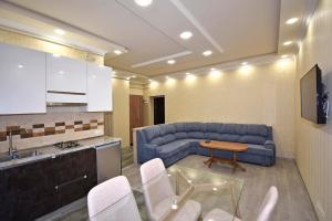 a living room with a blue couch and a table at Рядом с метро in Yerevan